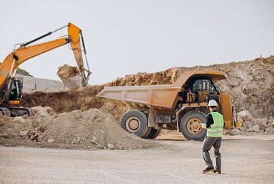 male worker with bulldozer sand quarry